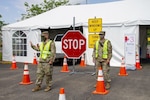 Kentucky National Guard Spc. Robert Acosta, a musician assigned to 202nd Army Band, and Pfc. Jacob Sharp, aircraft mechanic with the 351st Aviation Support Battalion, 63rd Theater Aviation Brigade, direct traffic at a COVID-19 testing facility in Shelbyville, Ky., June 24, 2020.