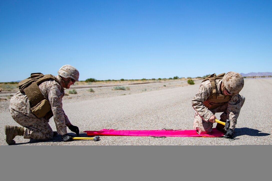 U.S. Marine Corps 1st Lt Lance Bell (left), an air traffic control officer, with Marine Air Control Squadron (MACS) 1 and LCpl Austin Pence, a coordinator, with Headquarter and Headquarters Squadron (HHS) set up an Assault Landing Zone (ALZ) for a KC-130J touch and go operation at Auxiliary Airfield II aboard Marine Corps Air Station (MCAS) Yuma training ground on June 9, 2020.