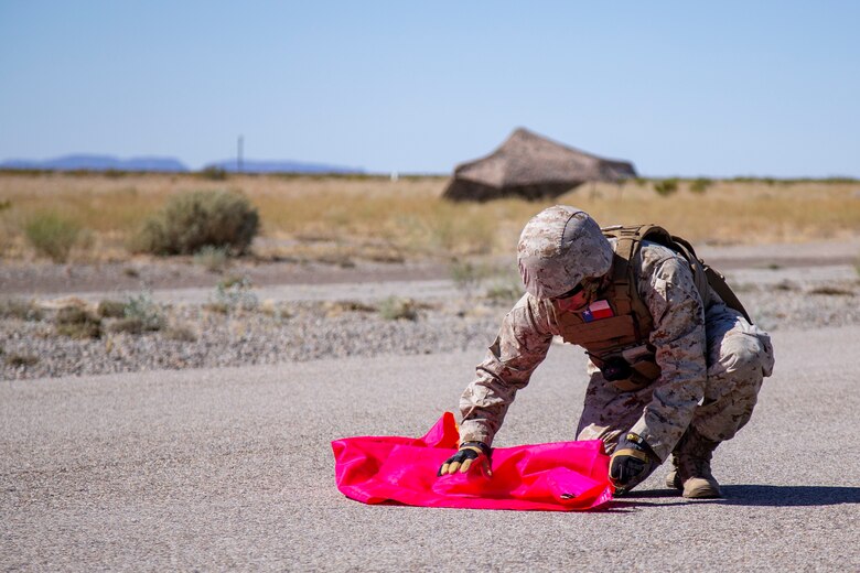 U.S. Marine Corps Cpl Jerry Collins, a radar final controller, with Headquarter and Headquarters Squadron (HHS) sets up an Assault Landing Zone (ALZ) for a KC-130J touch and go operation at Auxiliary Airfield II aboard Marine Corps Air Station (MCAS) Yuma training ground on June 9, 2020.(U.S. Marine Corps photo by LCpl Gabrielle Sanders)
