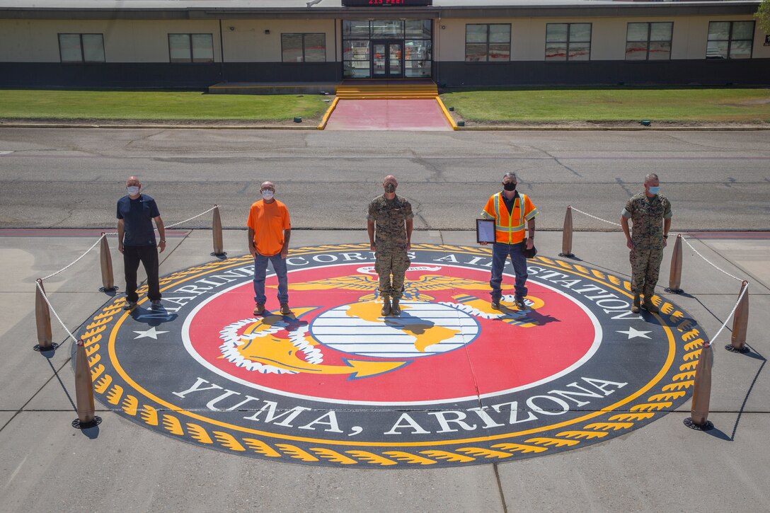 U.S. Marine Corps Col. David A. Suggs, commanding officer, Marine Corps Air Station (MCAS) Yuma, presents civilian contractors with a letter of appreciation (LOA) for their work on MCAS Yuma, at the MCAS Yuma base operations building, June 11, 2020.