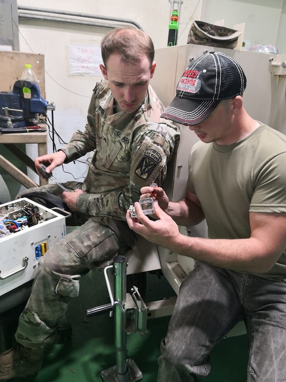 Phot of generator Technician Johnathan Persinger, right, works with Soldiers to repair environmental control units and generators