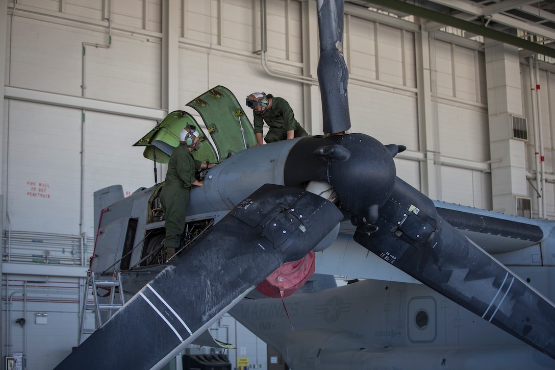 U.S. Marines Corps Cpl Kyle Sewer, left, and Cpl Reid Ellis Jr, MV-22 tiltrotor mechanics with Marine Operational Test and Evaluation Squadron (VMX) 1, conduct routine maintenance on a MV-22 Osprey on Marine Corps Air Station (MCAS) Yuma, June 18, 2020.