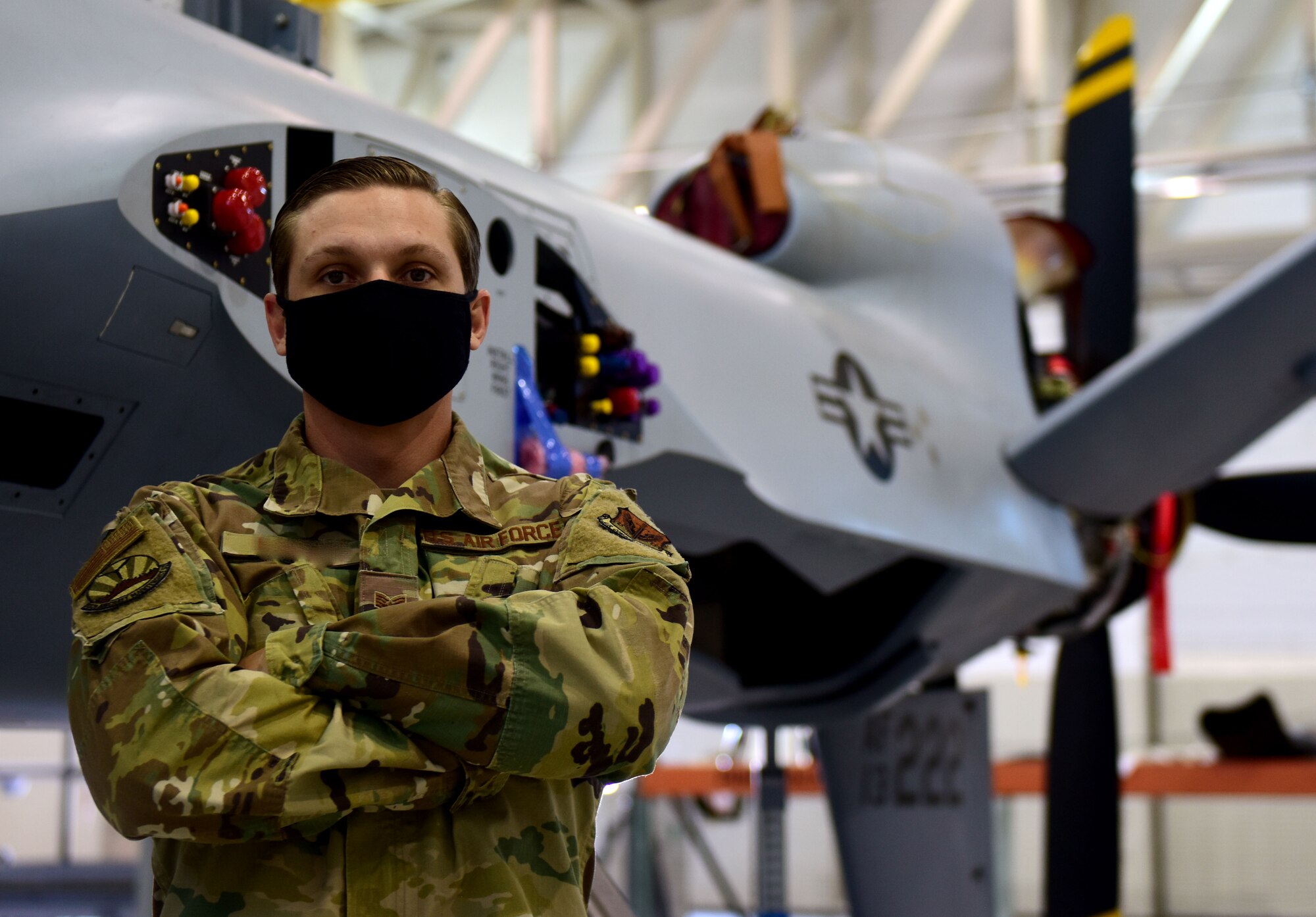 Staff Sgt. Anthony, 432nd Aircraft Maintenance Squadron crew chief, stands in front of an MQ-9 Reaper at Creech Air Force Base, Nev.