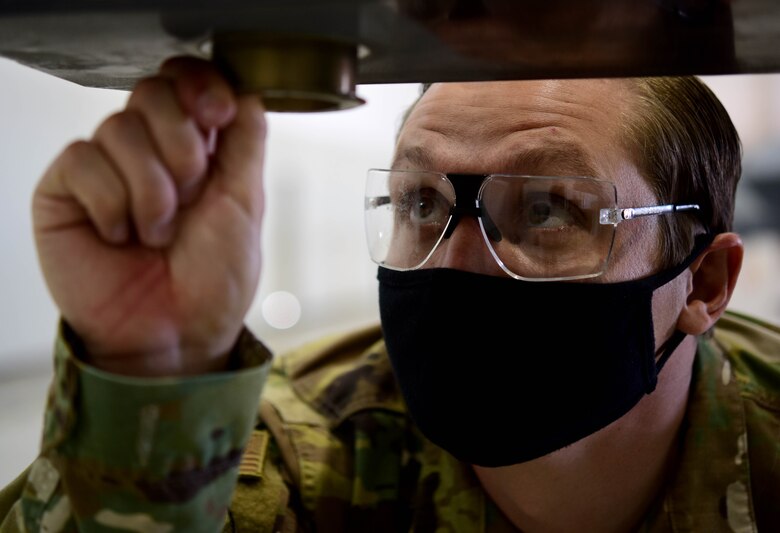 Staff Sgt. Anthony, 432nd Aircraft Maintenance Squadron crew chief, inspects a wing bushing.