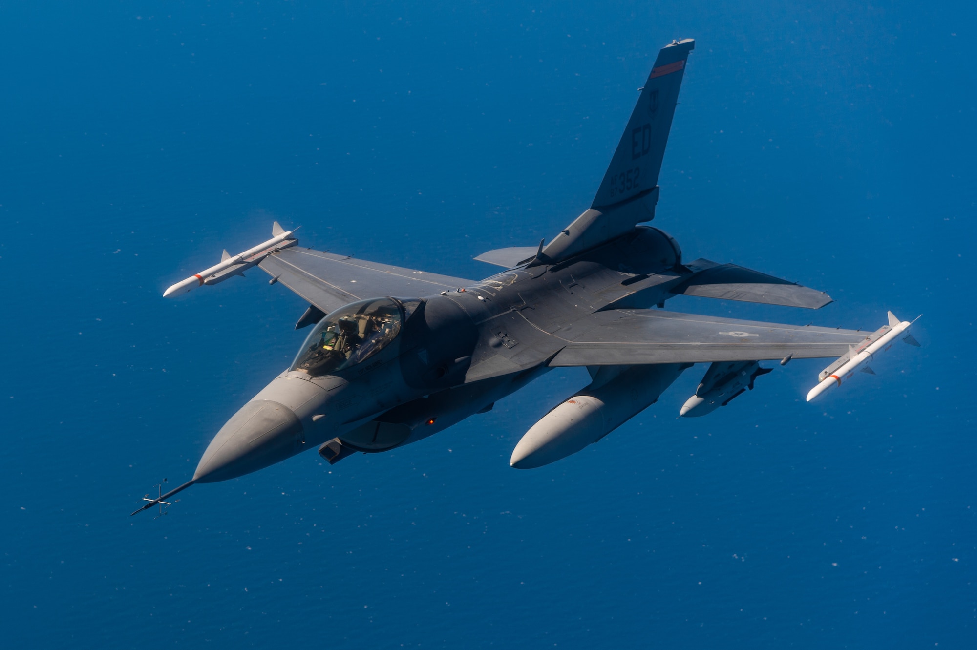 An F-16 Fighting Falcon flown by Maj. Jacob Schonig from the 416th Flight Test Squadron at Edwards Air Force Base, California, conducts a captive-carry flight test with a Gray Wolf cruise missile prototype over the Pacific Ocean, June 9. (Air Force photo by Ethan Wagner)