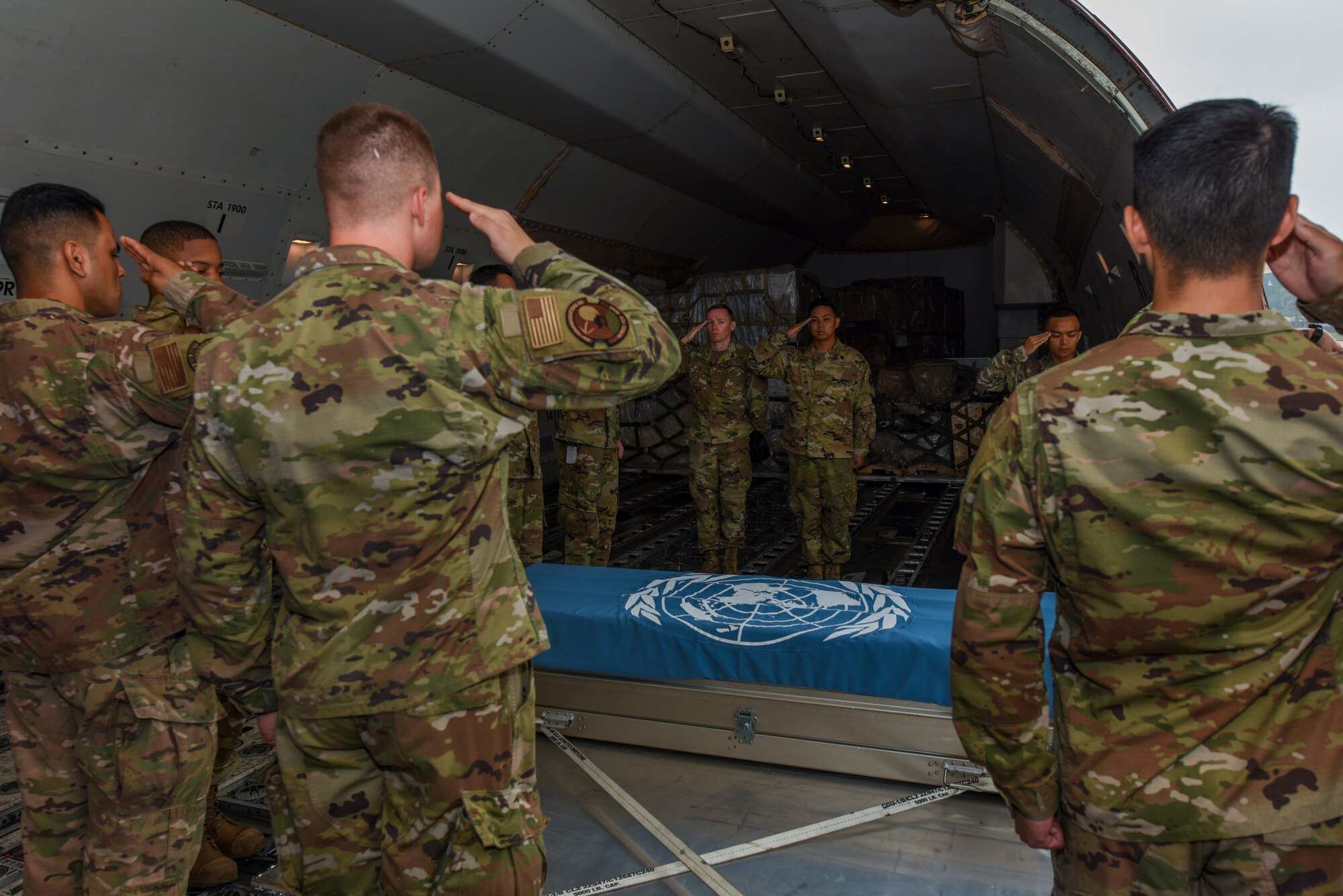 Airmen salute a transfer case during a repatriation