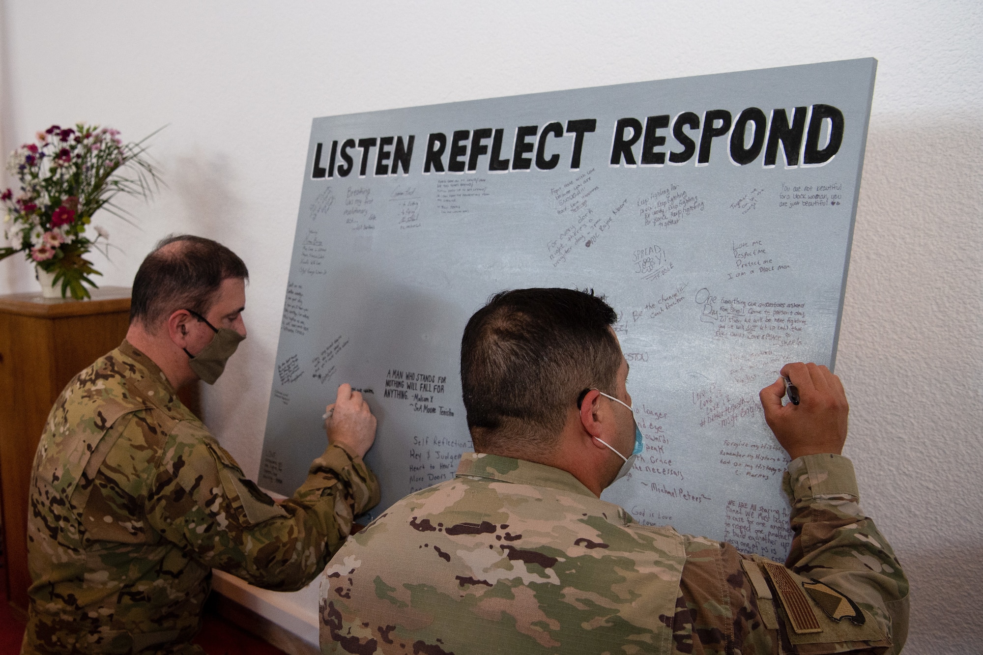 U.S. Air Force Brig. Gen. Mark R. August, 86th Airlift Wing commander, and Chief Master Sgt. Ernesto J. Rendon, 86th AW command chief, sign a message board during the Juneteenth: Vigil for Healing event at Ramstein Air Base, Germany, June 19, 2020.