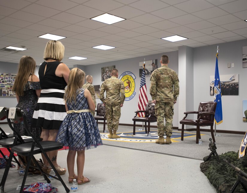 Airmen and their families stand at attention during the National Anthem at the 316th Security Forces Squadron change of command ceremony at Joint Base Andrews, Md., June 24, 2020.