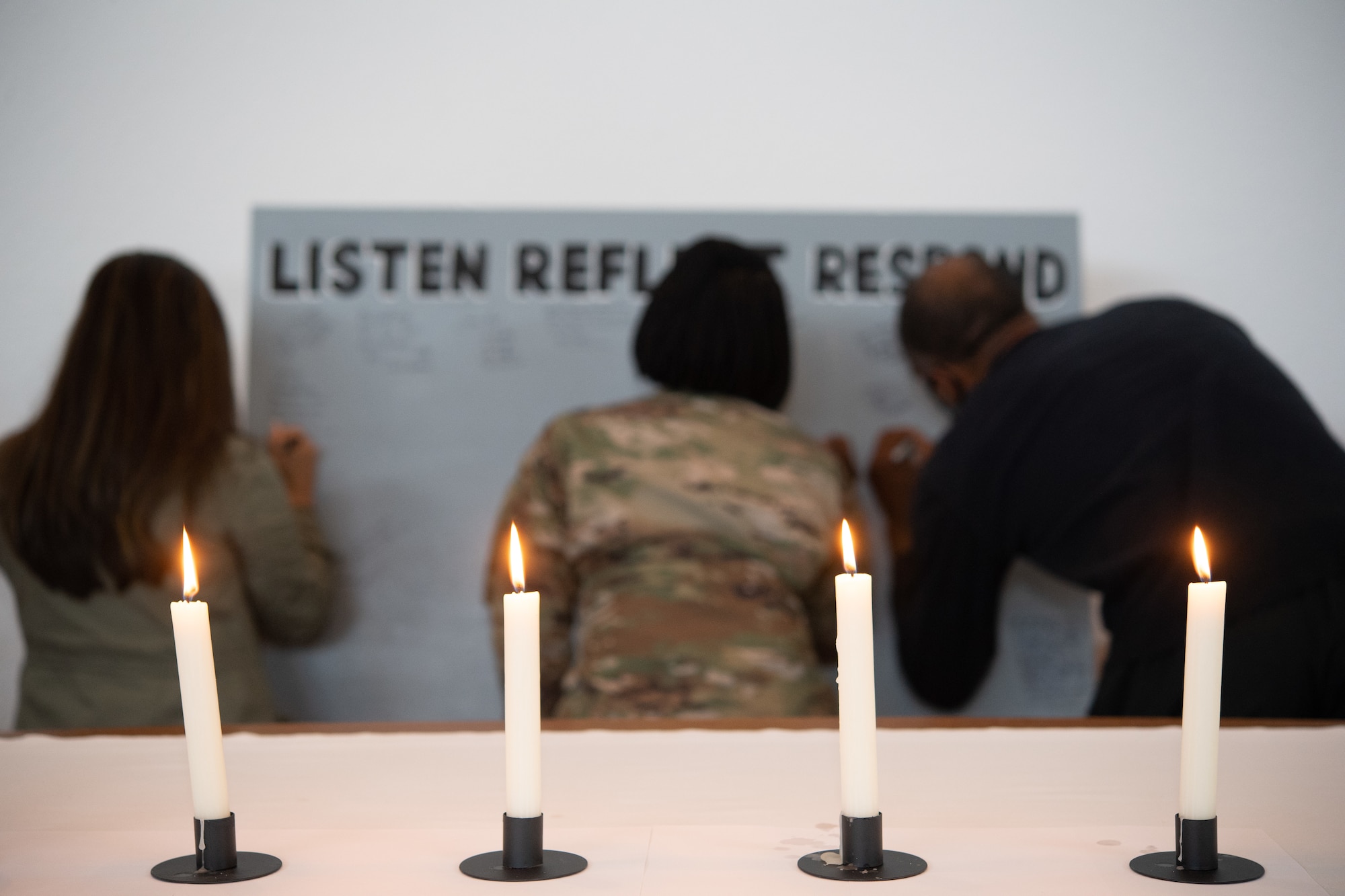 Kaiserslautern Military Community members sign a message board titled, “Listen, Reflect, Respond” following the Juneteenth: Vigil for Healing event at Ramstein Air Base, Germany, June 19, 2020.