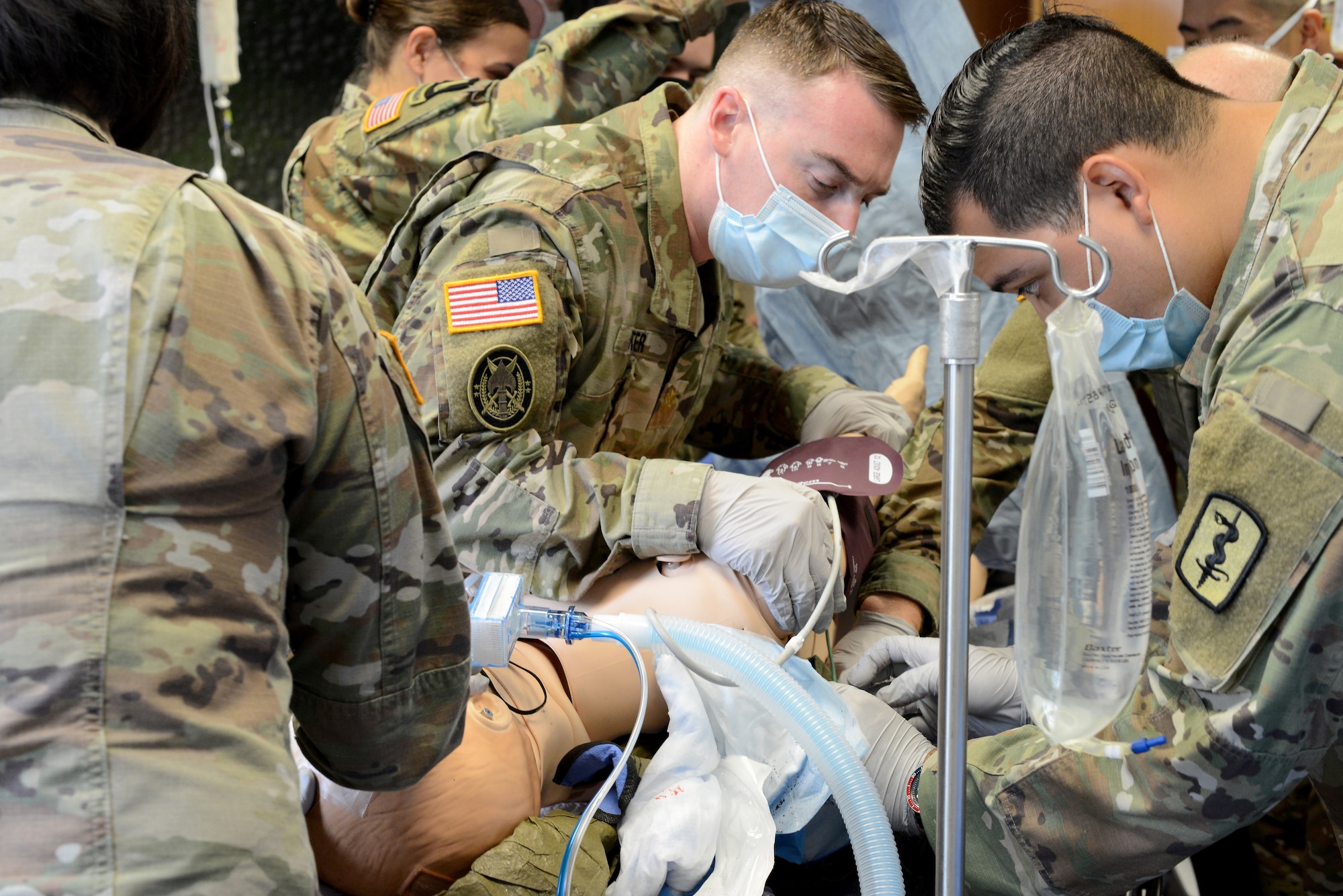 U.S. Army Maj. James Foster, 67th Forward Resuscitative Surgical Team orthopedic surgeon, left, and Spc. Jonathan Lopez, 67th FRST operating room technician, right, place a Hypothermia Prevention and Management Kit under the patient to prepare for transport during a training scenario at the Medical Simulation Training Center, Ramstein Air Base, June 19, 2020.