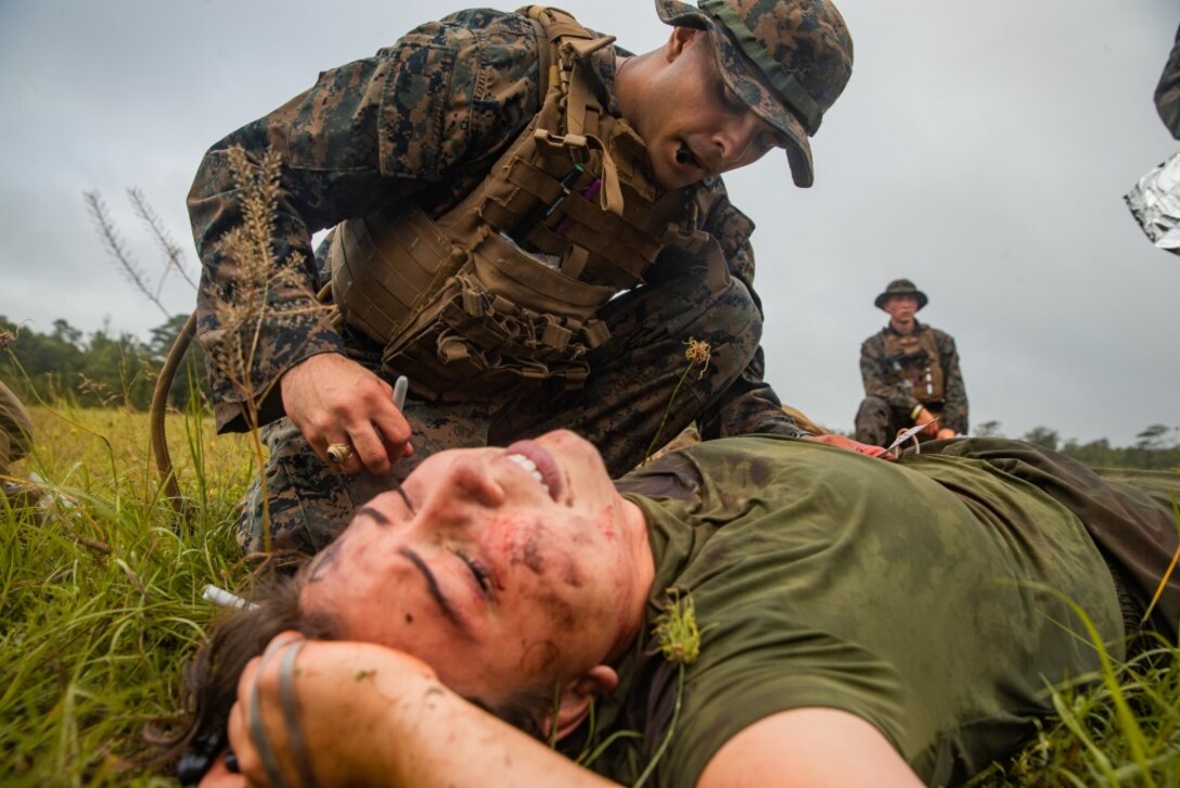 A U.S. Navy Petty Officer 3rd Class Christian Hart, a hospital corpsman with 2d Battalion, 2d Marine Regiment, 2d Marine Division (MARDIV), primes an intravenous fluid bag during a 10-mile trauma run at Camp Lejeune, North Carolina, June 17, 2020. The sailors participated in the HM3 (FMF) Aaron A. Kent Challenge, a three-day event consisting of physical fitness analyses, basic corpsman history, and practical knowledge of trauma treatment in a simulated combat environment. The event was held to honor corpsman who lost their lives in the heat of battle. (U.S. Marine Corps photo by Lance Cpl. Patrick King)