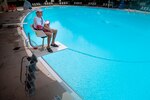 Lifeguard Brandon Mercado looks out over an empty pool at Joint Base San Antonio-Randolph on June 25, the second day the JBSA pools were open for the summer.