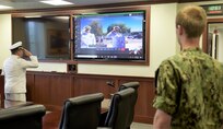 Capt. Nick Andrews, commanding officer of the Center for Information Warfare Training, renders a salute virtually to Capt. Errol Laumann, the outgoing commanding officer of Information Warfare Training Command (IWTC) San Diego, and Cmdr. Tim Raymie, the newest commanding officer of IWTC San Diego, during a change of command ceremony.