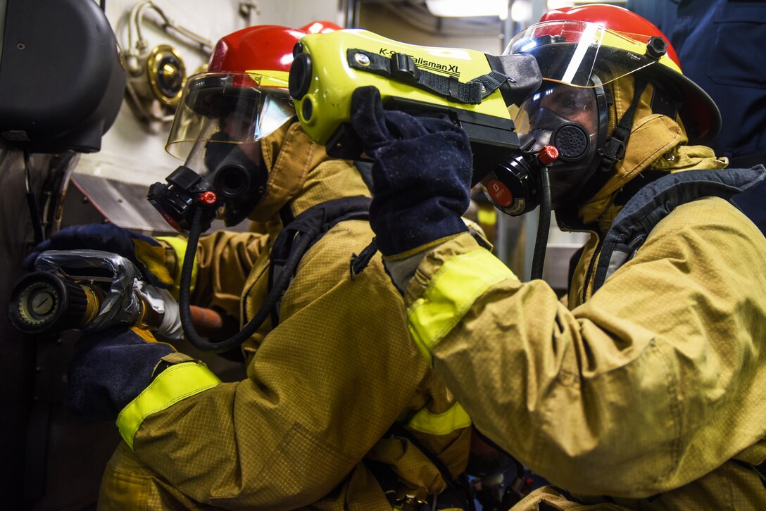 Two sailors use thermal imaging equipment during training.