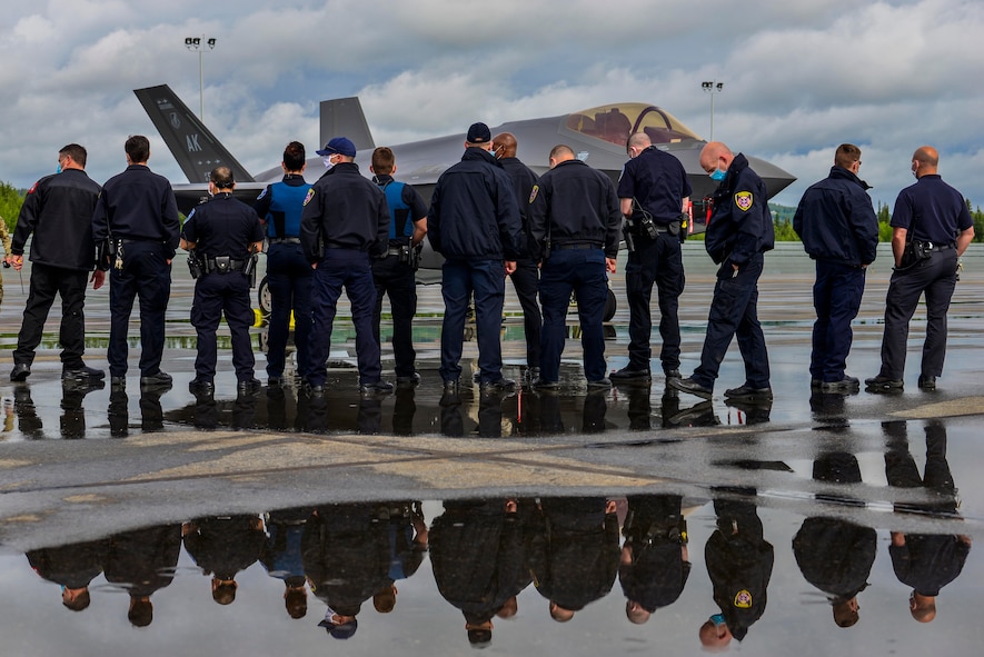 Fairbanks International Airport (FAI) Police and Fire Department personnel observe a U.S. Air Force F-35A Lightning II assigned to the 356th Fighter Squadron on the airport runway in Fairbanks, Alaska, June 24, 2020.