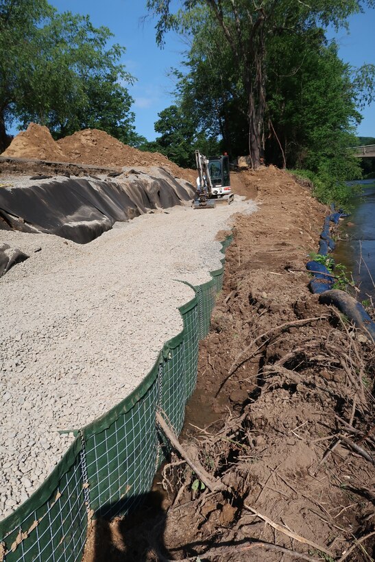 Heavy construction machinery fills temporary barriers with stone along the access road to and an embankment of a dam in Tionesta, Pennsylvania June 25, 2020.