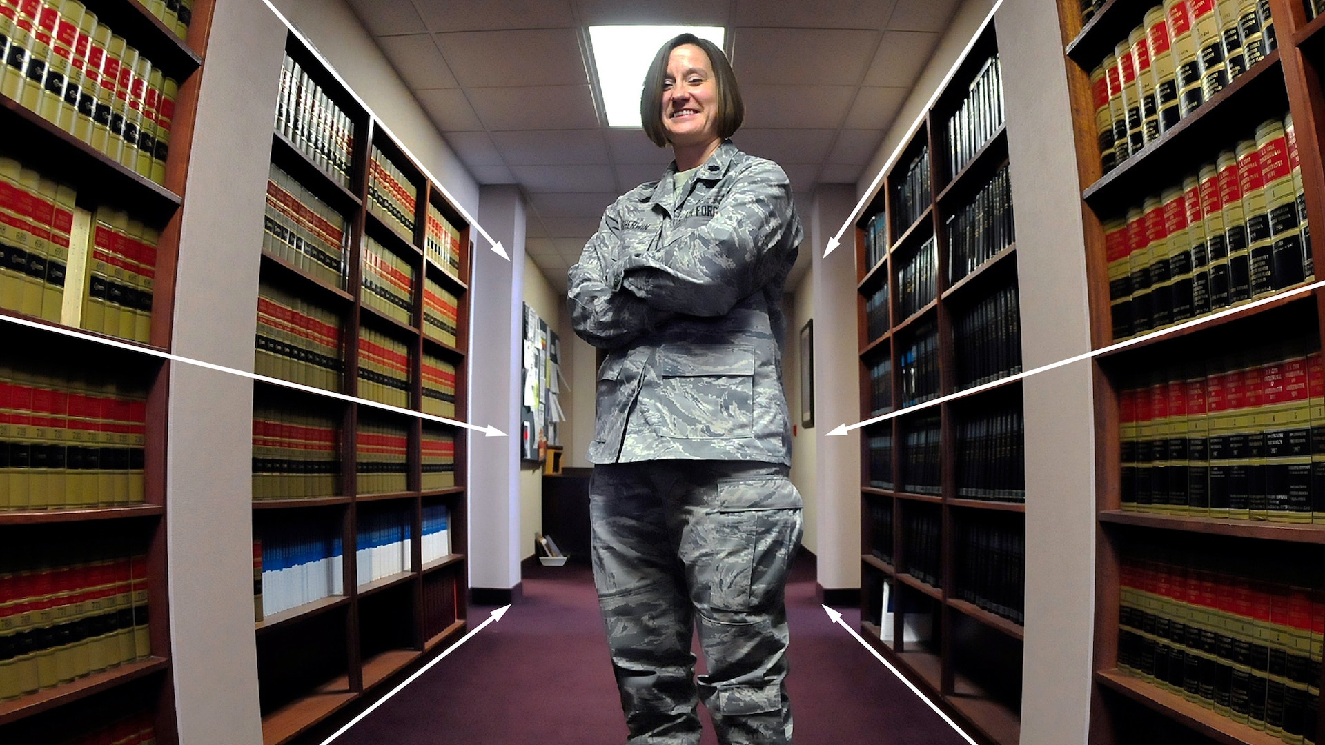 Fatigue-wearing service member stands in a room of books. Lines have been added to show how the angle of the shot contributes to the convergence.