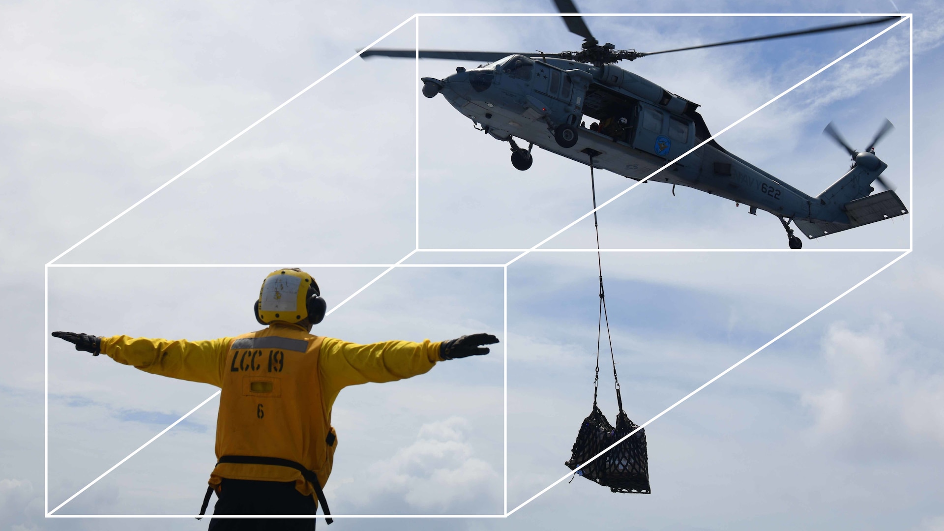 Airman signals to a helicopter during a shipboard delivery