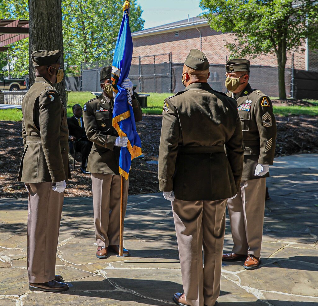 Lt. Col. Naim Lee holds the Army Acquisition Corps flag, as he is chartered as Product Manager, Soldier Clothing and Individual Equipment during the change of charter on Fort Belvoir, Virginia, June 12, 2020.