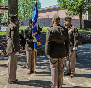Lt. Col. Naim Lee holds the Army Acquisition Corps flag, as he is chartered as Product Manager, Soldier Clothing and Individual Equipment during the change of charter on Fort Belvoir, Virginia, June 12, 2020.