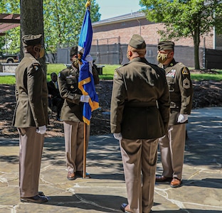 Lt. Col. Naim Lee holds the Army Acquisition Corps flag, as he is chartered as Product Manager, Soldier Clothing and Individual Equipment during the change of charter on Fort Belvoir, Virginia, June 12, 2020.