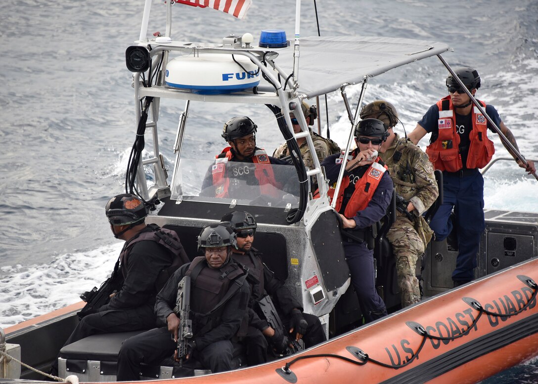 A small boat approaches a Coast Guard cutter.