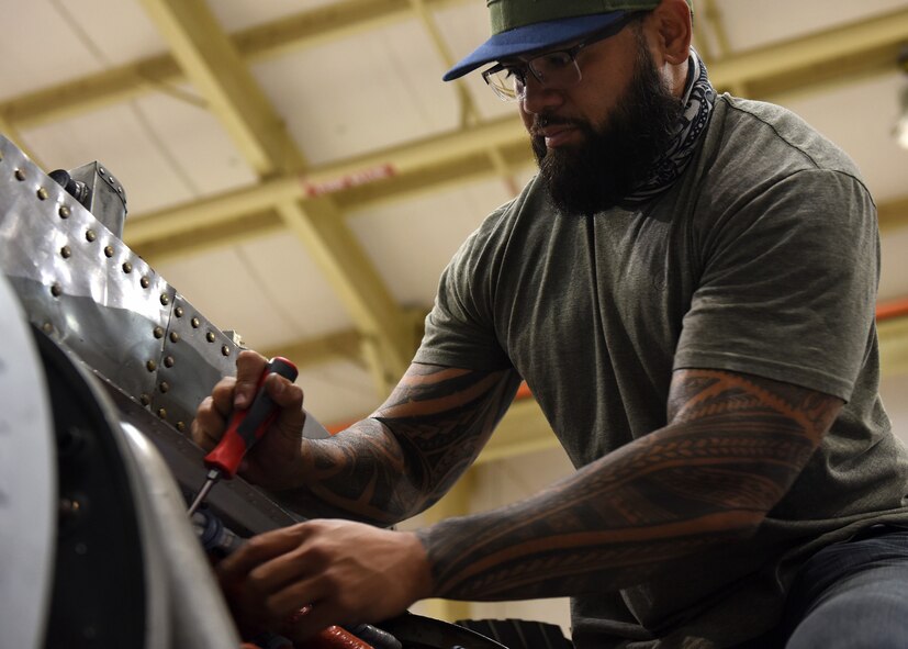 photo of an engine mechanic working on an aircraft engine