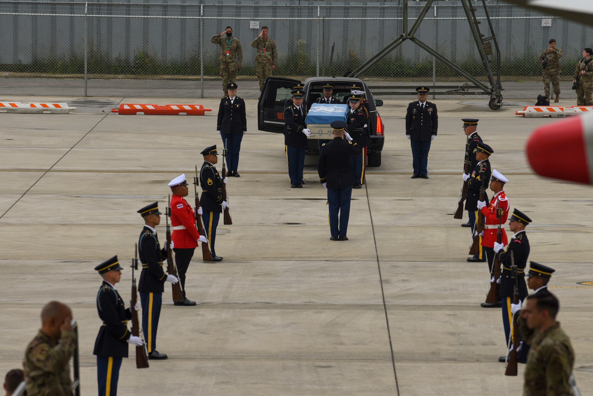 UNC Honor Guard carries a transfer case to an aircraft