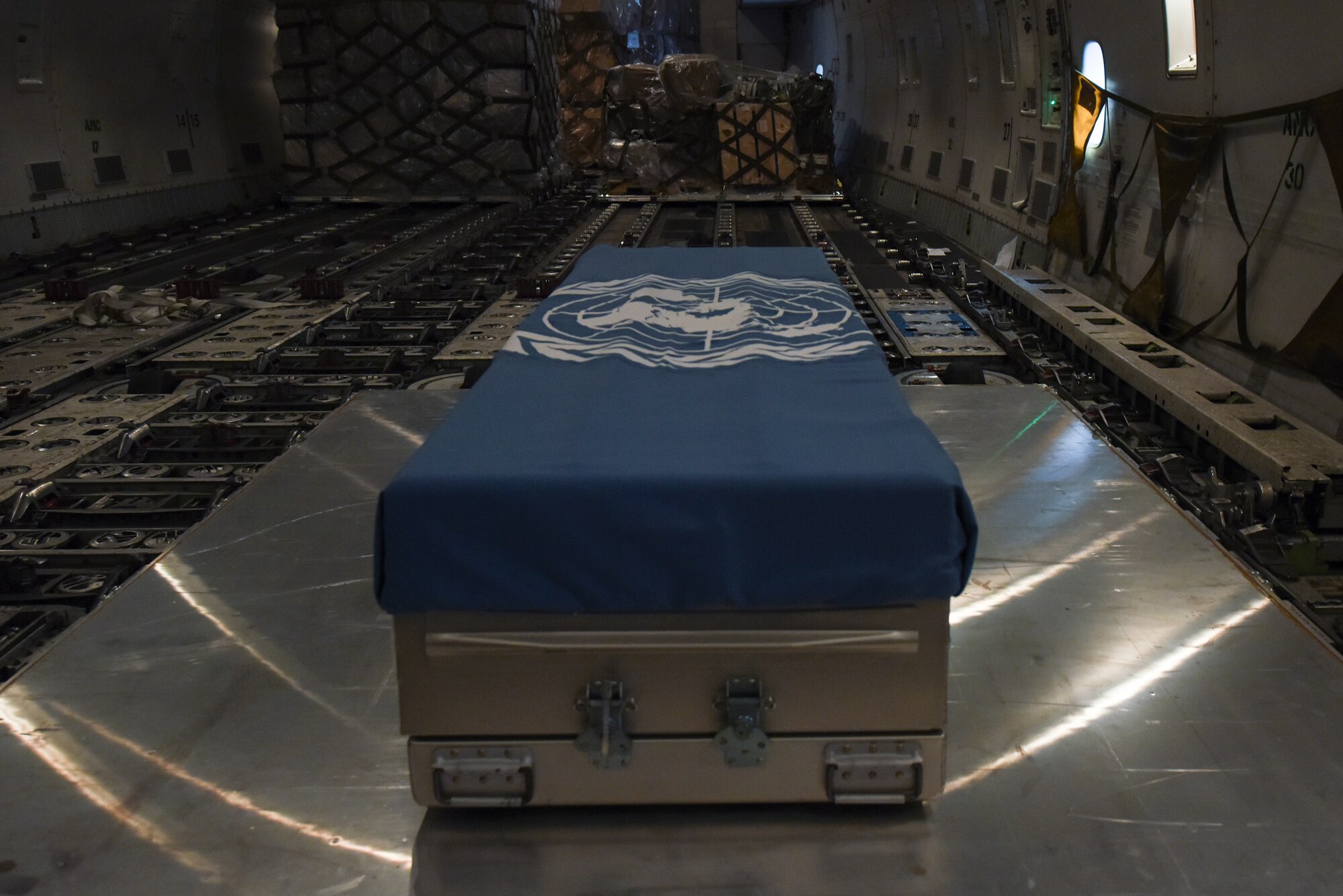 A United Nations Command flag is draped over a transfer case on aircraft