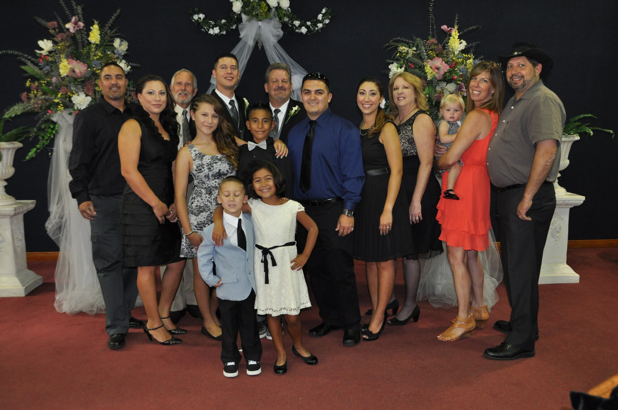 Marvin Tucker, emergency manager, 452nd Air Mobility Wing, and his new husband, Joshua Delgado, (back row, center) pose in the base chapel with Tucker's family after the couple exchanged vows and became the first same-sex couple to be married at the historic March Air Reserve Base on Aug. 3, 2013.