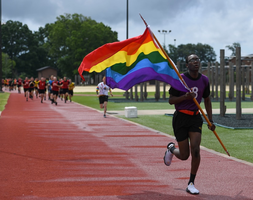A U.S. Army AIT Soldier carries a rainbow flag during a Pride Observance Month 5K run at Joint Base Langley-Eustis, Virginia, June 20, 2020.