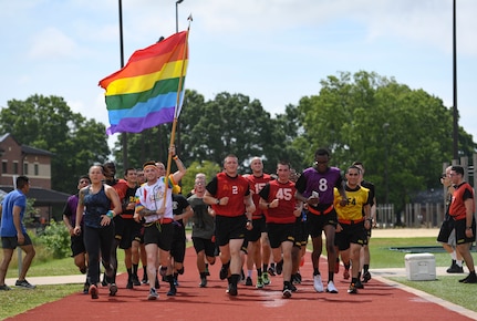 U.S. Army Sgt. Jimmy D. Tingle, Medical Department Activity patient administration specialist, runs with AIT Soldiers while carrying a rainbow flag during a Pride Observance Month 5K run at Joint Base Langley-Eustis, Virginia, June 20, 2020.