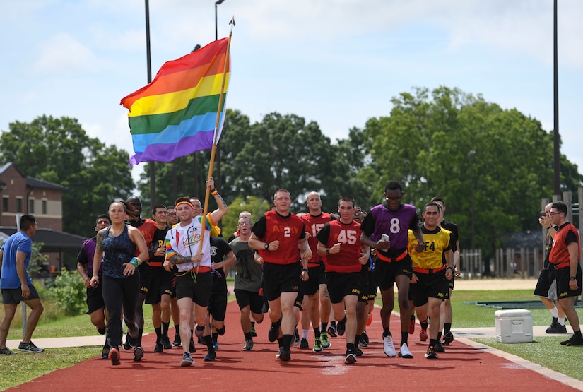U.S. Army Sgt. Jimmy D. Tingle, Medical Department Activity patient administration specialist, runs with AIT Soldiers while carrying a rainbow flag during a Pride Observance Month 5K run at Joint Base Langley-Eustis, Virginia, June 20, 2020.