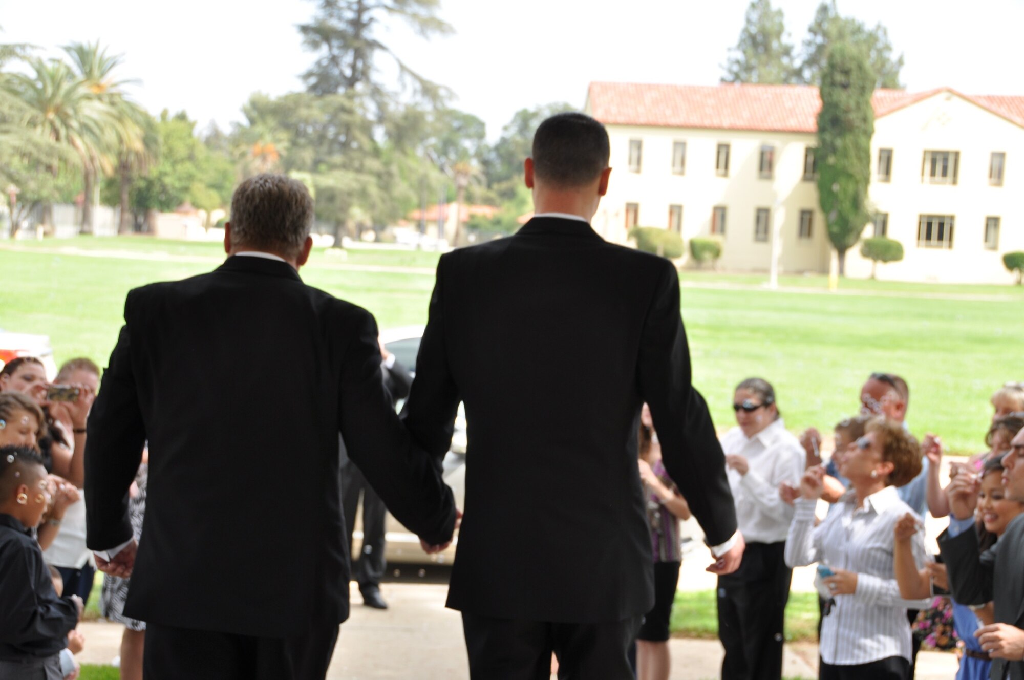 Marvin Tucker, emergency manager, 452nd Air Mobility Wing (left), and his new husband, Joshua Delgado, exit the historic March Air Reserve Base chapel Aug. 3, 2013, to celebrating guests, after the couple became the first same-sex couple to be married on the base