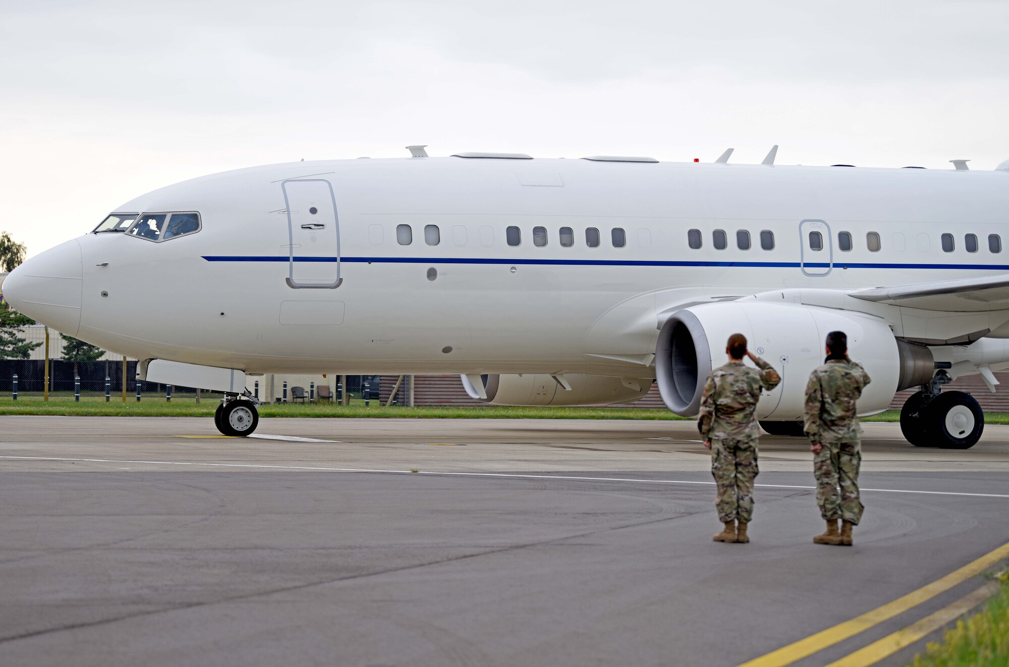 Chief Master Sgt. Kathi Glascock, 100th Air Refueling Wing command chief, and Col. S. Troy Pananon, salute as U.S. Secretary of Defense Dr. Mark T. Esper’s C-40 Clipper departs from RAF Mildenhall, England, June 26, 2020. Esper toured the air traffic control tower, static displays of a CV-22 Osprey, RC-135 Rivet Joint and spent time speaking with both officer and enlisted Airmen during his tour. (U.S. Air Force photo by Senior Airman Brandon Esau)