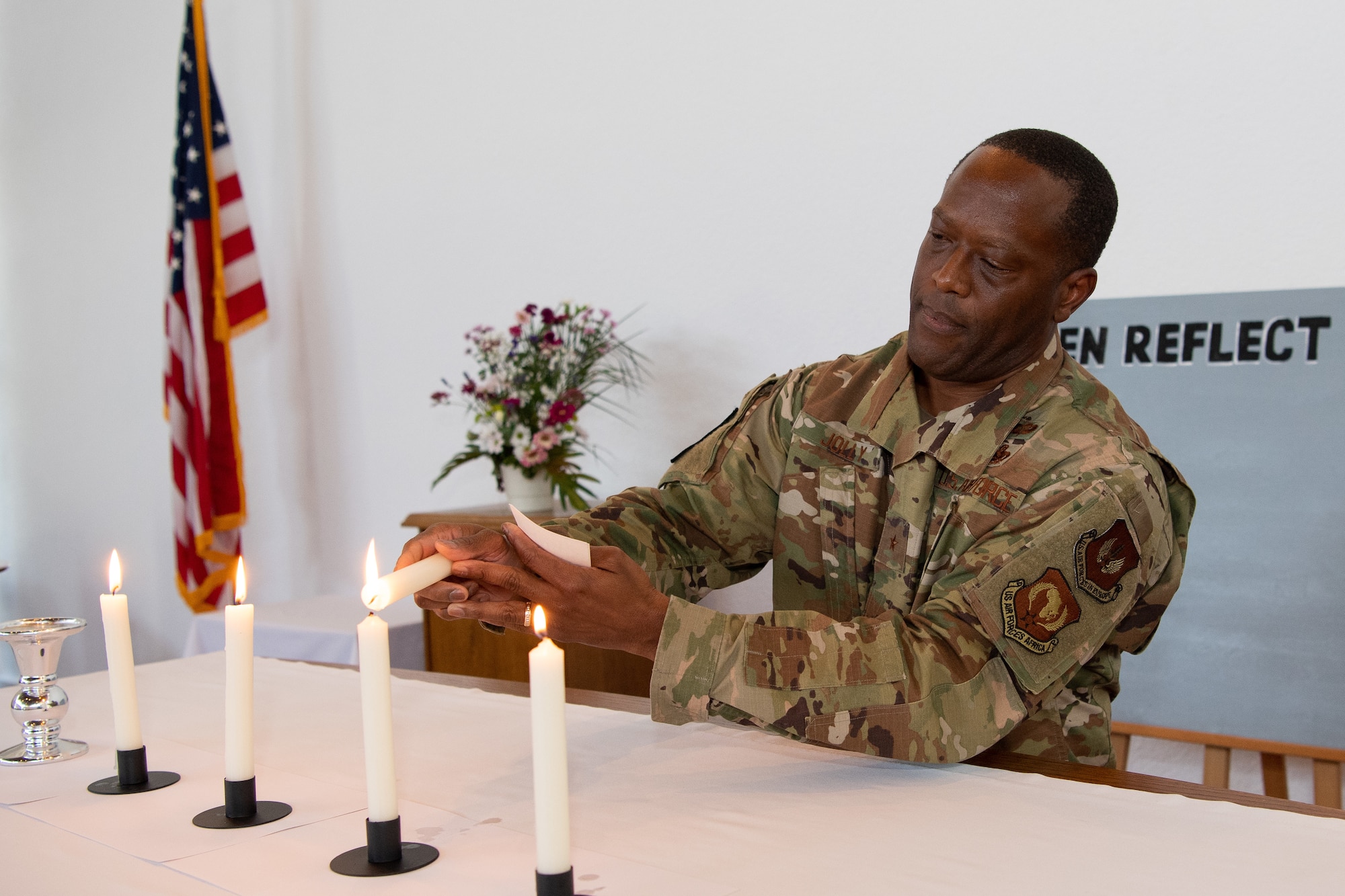 U.S. Air Force Brig. Gen. Ronald E. Jolly Sr., U.S. Air Forces in Europe and Air Forces Africa logistics, engineering and force protection director, lights a candle after giving a speech during the Juneteenth: Vigil for Healing event at Ramstein Air Base, Germany, June 19, 2020.