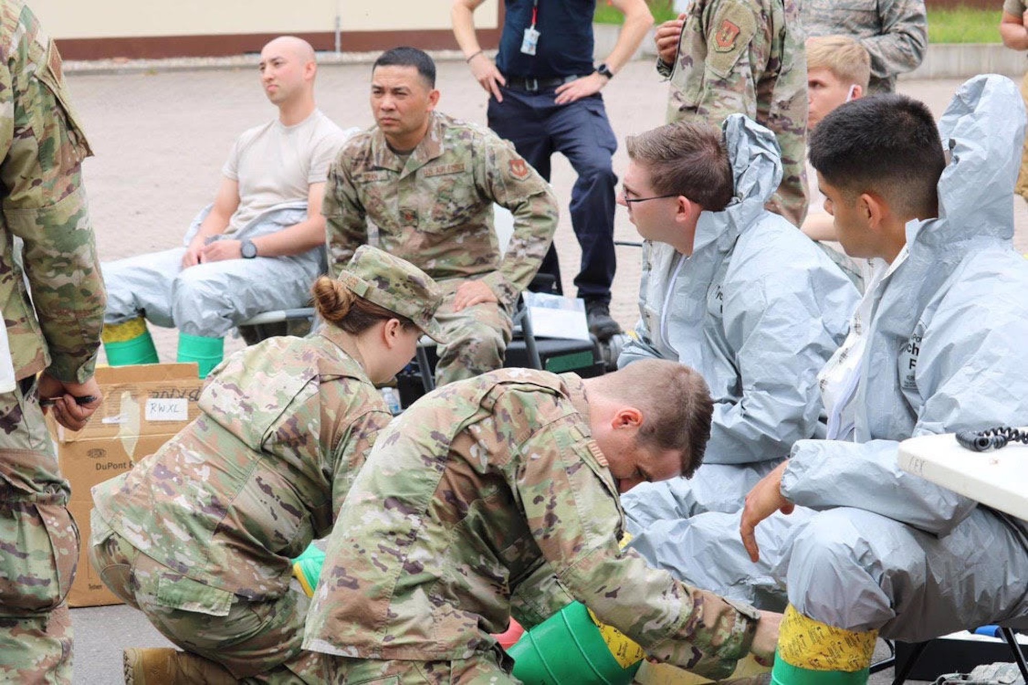 U.S. Air Force Airmen, assigned to the 786th Civil Engineer Squadron Emergency Management flight assist fellow Airmen by taping their Level B suits with protective ChemTape in preparation for entry into a potentially contaminated area at Landstuhl Regional Medical Center, Germany, June 16, 2020.