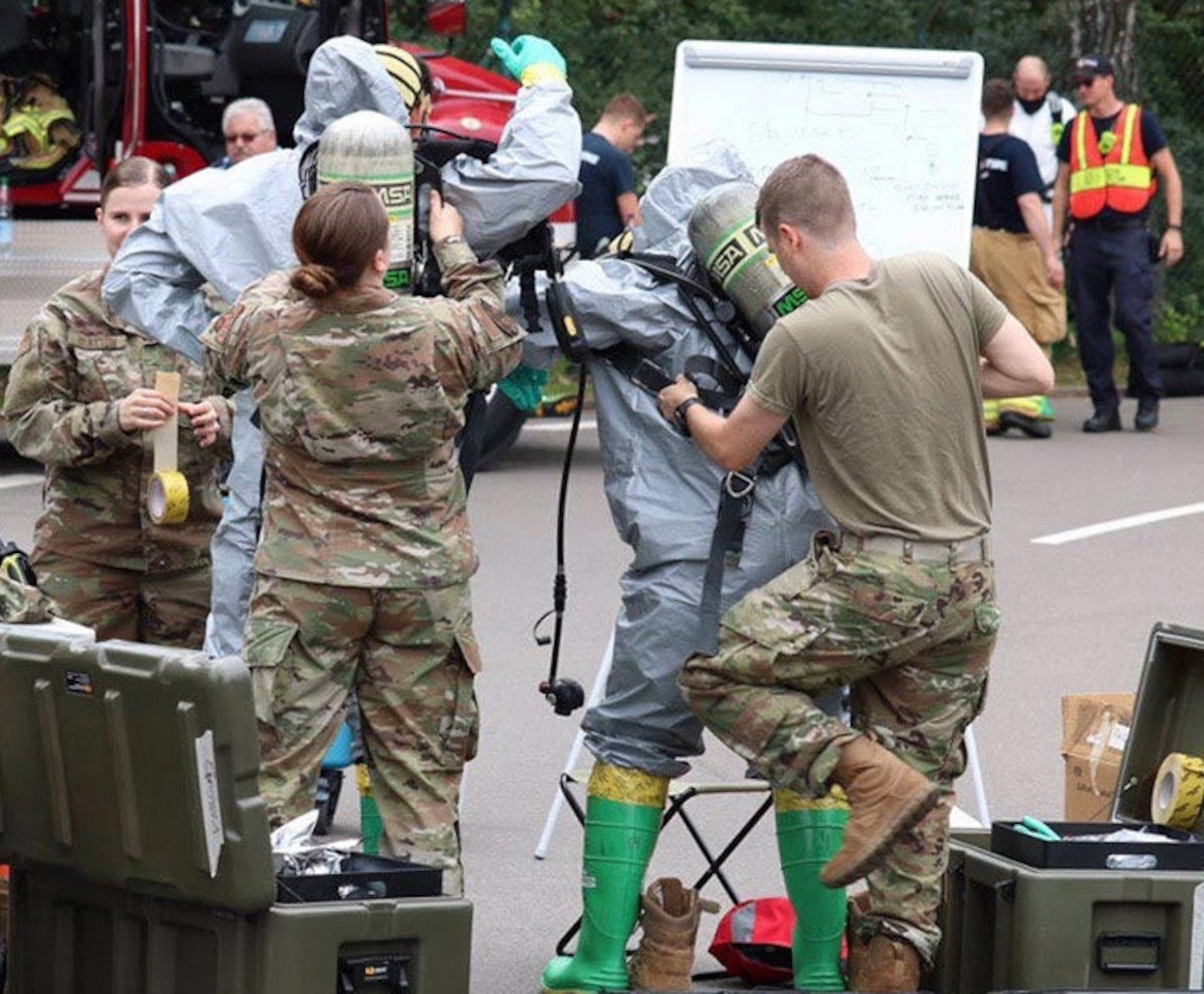 U.S. Air Force Airmen, assigned to the 786th Civil Engineer Squadron Emergency Management flight assist fellow Airmen on response Team 1 don personal protective equipment in Level B suits so they can safely make entry into a potentially contaminated area at Landstuhl Regional Medical Center, Germany, June 16, 2020.