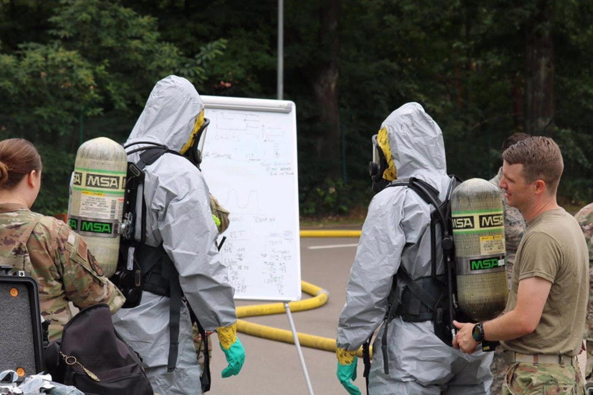 U.S. Air Force Airmen, assigned to the 786th Civil Engineer Squadron Emergency Management Logistics, review the team objectives before entry into a potentially contaminated area at Landstuhl Regional Medical Center, Germany, June 16, 2020.
