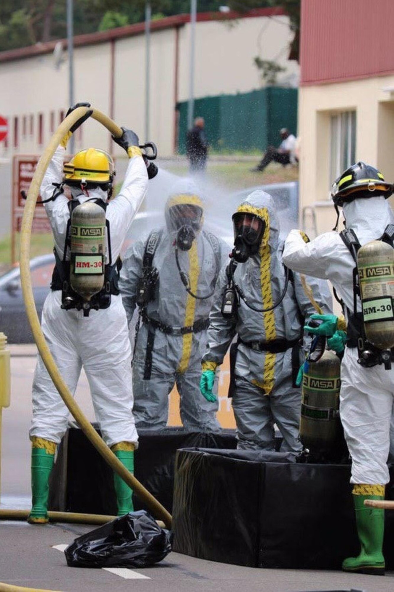 U.S. Air Force Airman 1st Class Raul Vargas, 786th Civil Engineer Squadron Emergency Management Logistics apprentice, and Staff Sgt. Erickson Zinger, 786th CES EM Logistics noncommissioned officer in charge, go through technical decontamination, provided by the 86th CES Fire Department, as they return from the incident area to a clean zone.