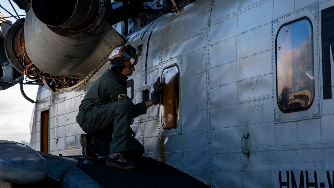 U.S. Marine Corps Lance Cpl. Evan Hughes, a CH-53E Super Stallion crew chief with Marine Medium Tiltrotor Squadron 164 (Reinforced), 15th Marine Expeditionary Unit, readies a CH-53E Super Stallion helicopter prior to conducting helocast training at Marine Corps Air Station Camp Pendleton, California, June 24, 2020. Helocasting is a method of insertion where Marines extract from a helicopter over a body of water; at the point of insertion, Marines will use a combat rubber raiding craft, or in some cases swim, to reach an objective. (U.S. Marine Corps photo by Lance Cpl. Mackenzie Binion)
