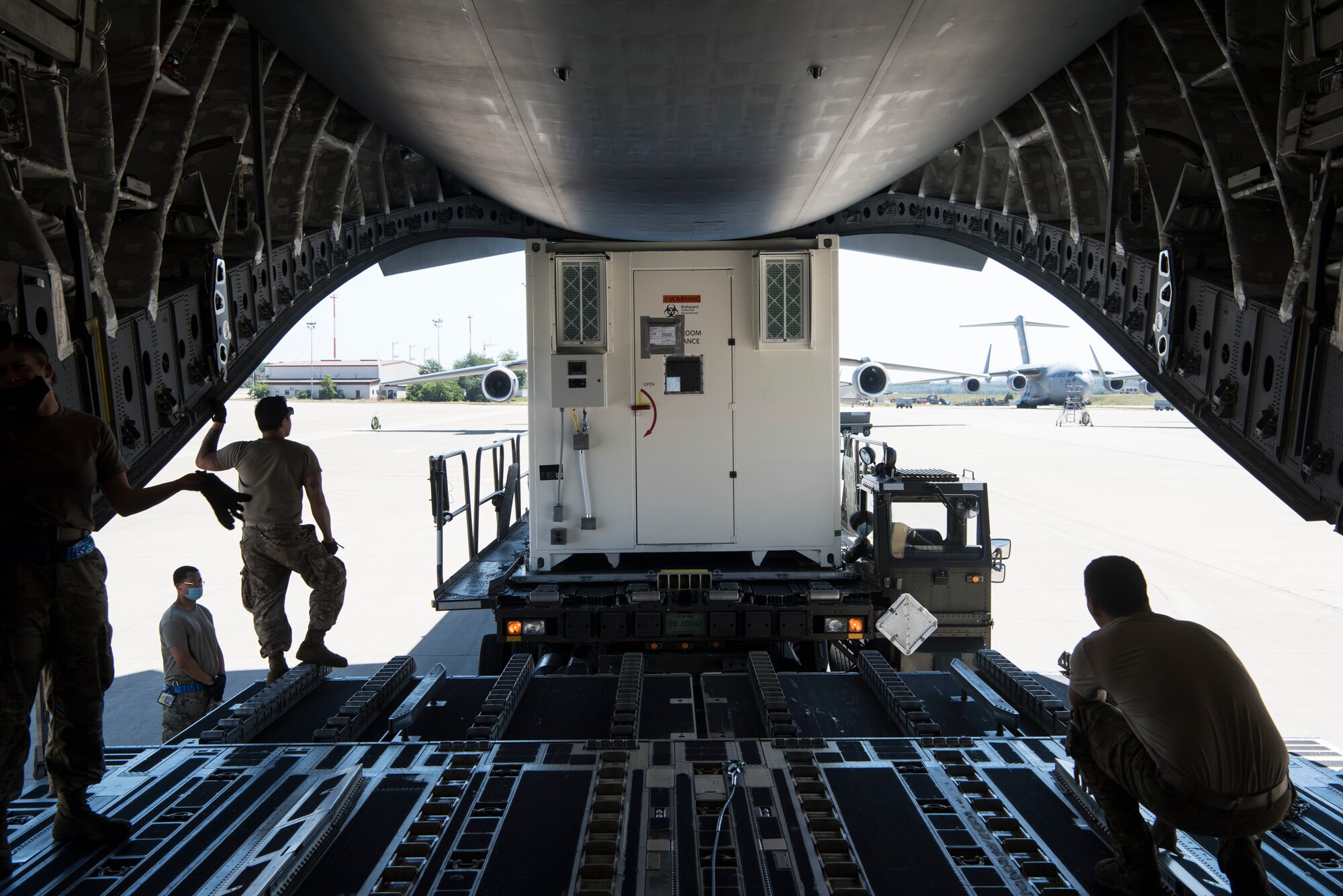 U.S. Air Force personnel assigned to the 721st Aerial Port Squadron load a Negatively Pressured Conex onto a C-17 Globemaster III aircraft