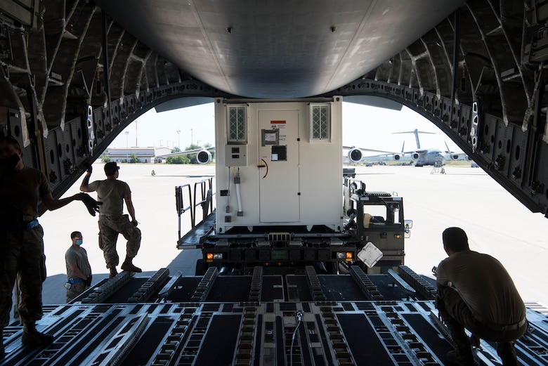 U.S. Air Force personnel assigned to the 721st Aerial Port Squadron load a Negatively Pressured Conex onto a C-17 Globemaster III aircraft