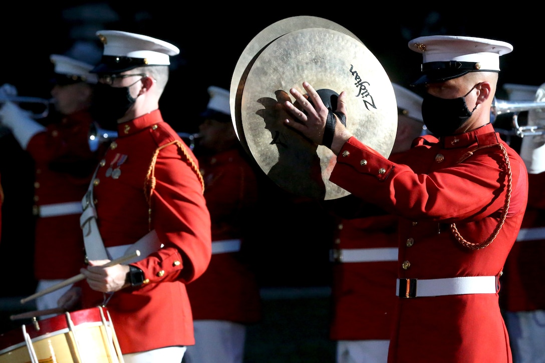 Lance Cpl. Erik Lindquist, percussionist, “The Commandant’s Own,” United States Marine Drum and Bugle Corps, plays the cymbals during the Friday Evening Parade at Marine Barracks Washington, D.C., June 26, 2020. Following Department of Defense guidelines and Centers for Disease Control and Prevention (CDC) recommendations, Marines are wearing cloth face coverings during parades this year in an effort to maximize the health and safety of Barracks personnel and guests. The hosting official for the evening was Col. Teague A. Pastel,  commanding officer, Marine Barracks Washington,and the 38th Commandant of the Marine Corps, Gen. David H. Berger, was the guest of honor. (U.S. Marine Corps photo by Sgt. Robert Knapp)