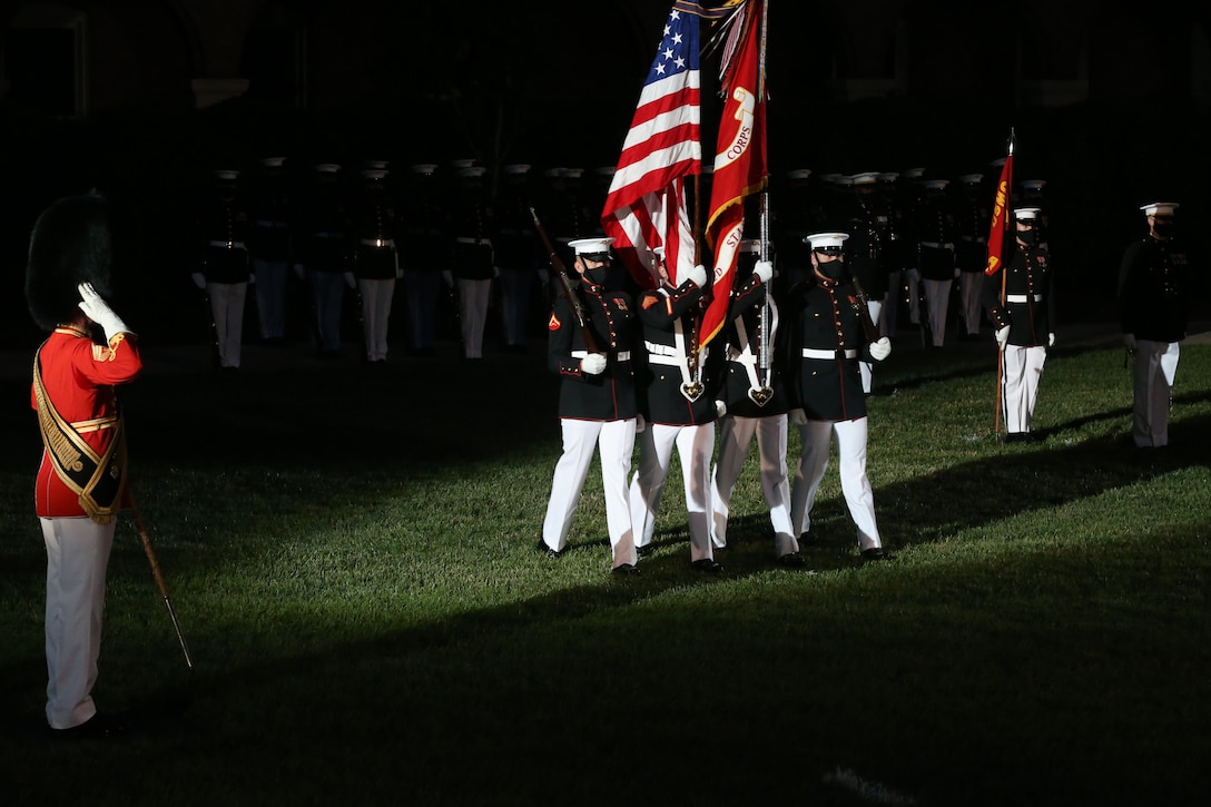 Master Gunnery Sgt. Duane King, left, drum major, “The President’s Own,” United States Marine Band, salutes as the Marine Corps Color Guard passes by during the Friday Evening Parade at Marine Barracks Washington, D.C., June 26, 2020. Following Department of Defense guidelines and Centers for Disease Control and Prevention (CDC) recommendations, Marines are wearing cloth face coverings during parades this year in an effort to maximize the health and safety of Barracks personnel and guests. The hosting official for the evening was Col. Teague A. Pastel, commanding officer, Marine Barracks Washington, and the 38th Commandant of the Marine Corps, Gen. David H. Berger, was the guest of honor. (U.S. Marine Corps photo by Sgt. Robert Knapp)