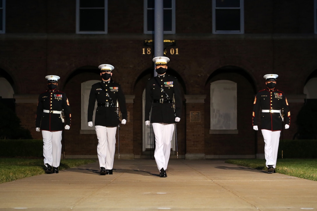 The parade staff marches down center walk during the Friday Evening Parade at Marine Barracks Washington, D.C., June 26, 2020. Following Department of Defense guidelines and Centers for Disease Control and Prevention (CDC) recommendations, Marines are wearing cloth face coverings during parades this year in an effort to maximize the health and safety of Barracks personnel and guests. The hosting official for the evening was Col. Teague A. Pastel, commanding officer, Marine Barracks Washington, and the 38th Commandant of the Marine Corps, Gen. David H. Berger, was the guest of honor. (U.S. Marine Corps photo by Lance Cpl. Allen Sanders)