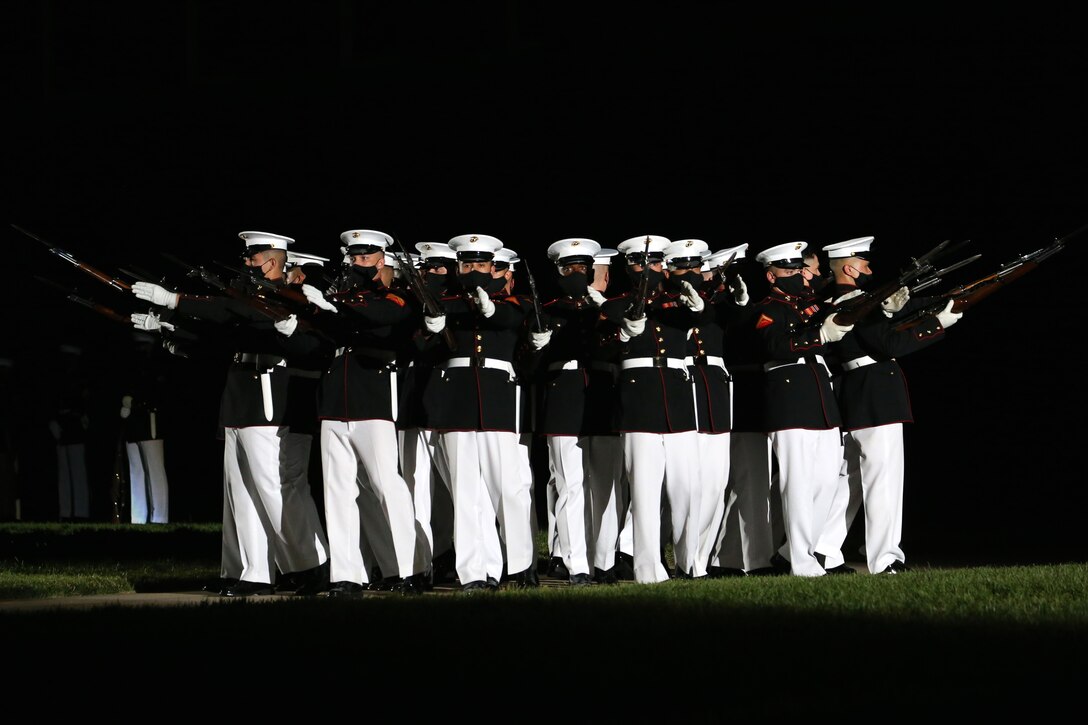 Marines with the Silent Drill Platoon execute the “bursting bomb” sequence during the Friday Evening Parade at Marine Barracks Washington, D.C., June 26, 2020. Following Department of Defense guidelines and Centers for Disease Control and Prevention (CDC) recommendations, Marines are wearing cloth face coverings during parades this year in an effort to maximize the health and safety of Barracks personnel and guests. The hosting official for the evening was Col. Teague A. Pastel, commanding officer, Marine Barracks Washington, and the 38th Commandant of the Marine Corps, Gen. David H. Berger, was the guest of honor. (U.S. Marine Corps photo by Lance Cpl. Allen Sanders)