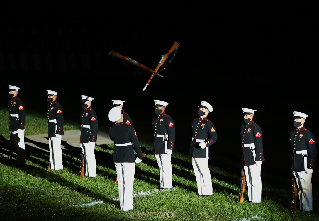 Marines with the Silent Drill Platoon execute precision rifle drill movements during the Friday Evening Parade at Marine Barracks Washington, D.C., June 26, 2020. Following Department of Defense guidelines and Centers for Disease Control and Prevention (CDC) recommendations, Marines are wearing cloth face coverings during parades this year in an effort to maximize the health and safety of Barracks personnel and guests. The hosting official for the evening was Col. Teague A. Pastel, commanding officer, Marine Barracks Washington, and the 38th Commandant of the Marine Corps, Gen. David H. Berger, was the guest of honor. (U.S. Marine Corps photo by Lance Cpl. Allen Sanders)