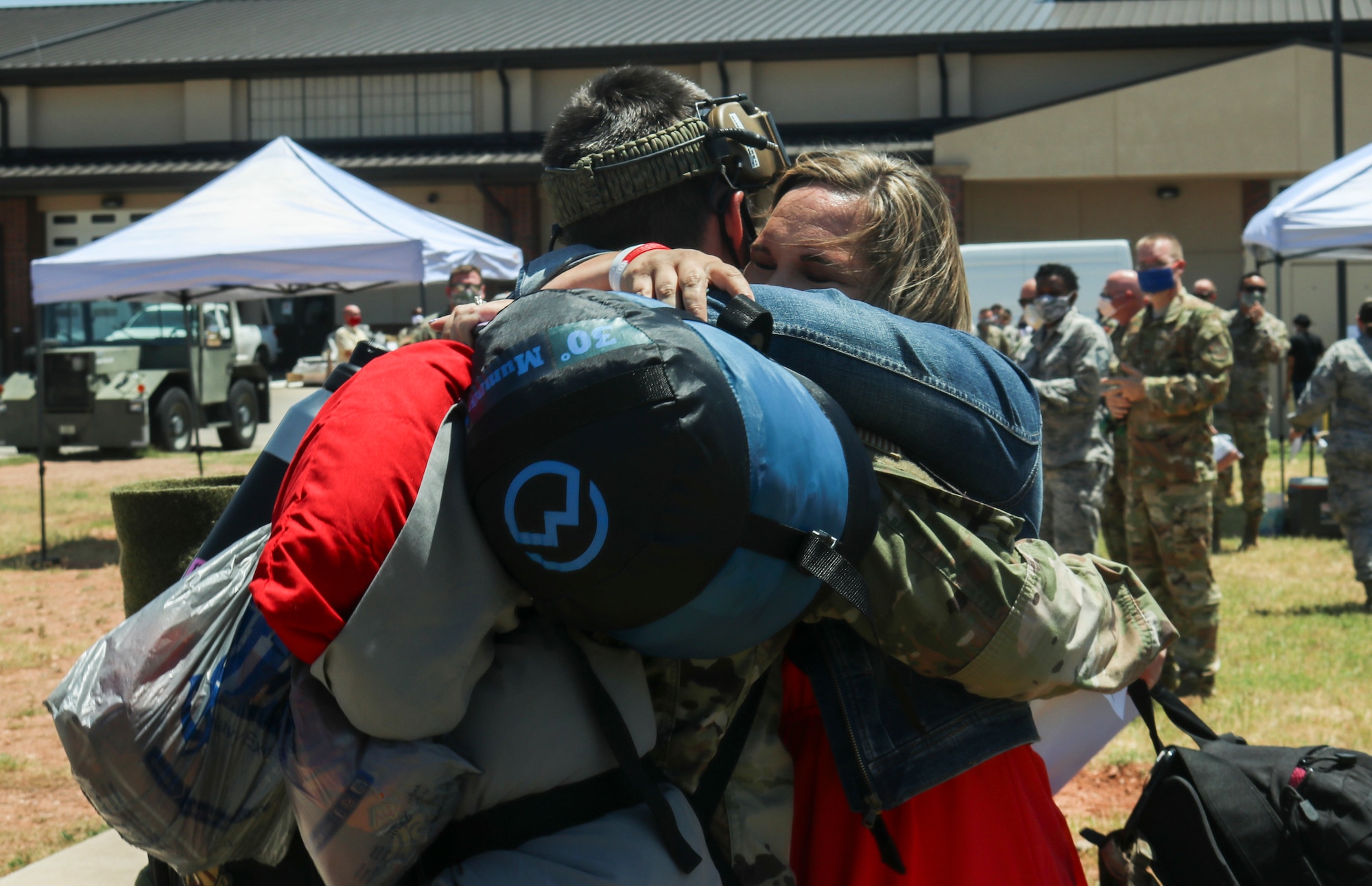 Master Sgt. Jason McGinnis, 317th Aircraft Maintenance Squadron production superintendent, hugs his wife, Lisa McGinnis, after returning from a deployment to Djibouti, Africa, at Dyess Air Force Base, Texas, May 18, 2020. Family members have access to a multitude of resources across the base to help them while their military spouses are deployed. (U.S. Air Force photo by Staff Sgt. David Owsianka)