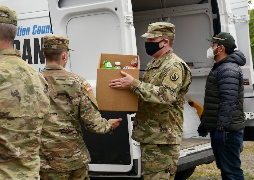 Guardsmen unload food from a truck.
